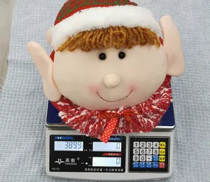 Christmas elf head tree topper on scale showing 389.9g weight with plush hat and red collar