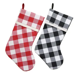 Classic red and black plaid Christmas stockings with white trim hanging fireplace decor
