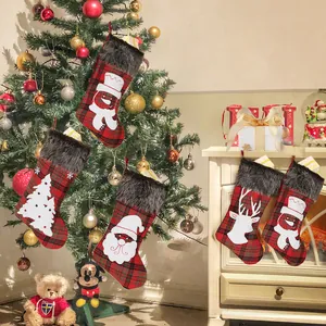 Plaid Christmas stockings set with Santa and reindeer motifs near a festive tree