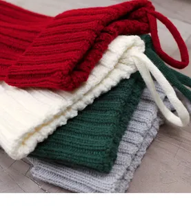 Dettaglio di quattro calze di Natale in maglia spessa nei colori rosso, bianco e grigio