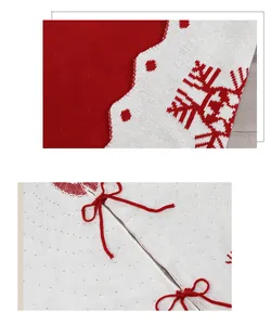 Detail van de rood-witte gebreide kerstboomschort met sneeuwvlokken en strikjes