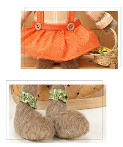 Detalle de conejo de Pascua de peluche con delantal naranja, botones de madera y cesta pequeña