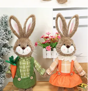 Detalle de conejitos de Pascua de peluche con ropa a cuadros y una zanahoria