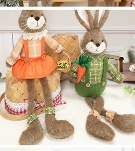 Detalle de conejitos de Pascua sentados con patas largas suaves y accesorios de zanahoria