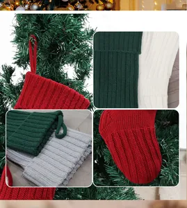 Dettaglio di calze di Natale in maglia rosse e bianche appese a un ramo dell'albero