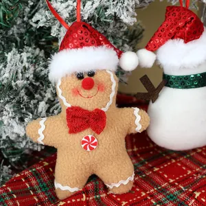 Peperkoekman pluche kersthanger met lovertjes hoed op een besneeuwde kerstboom