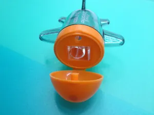 Detail view of the orange cartoon airplane pencil sharpener with open bottom cover