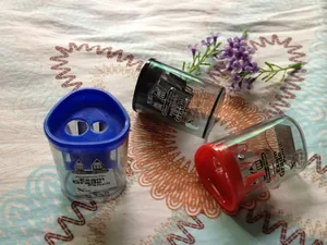 Dual-hole manual pencil sharpener for 8mm to 12mm pencils in blue, black, and red colors