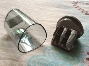 Close-up of a dual-hole pencil sharpener with a translucent grey reservoir and label