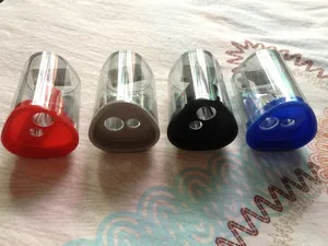 Close-up of dual-hole pencil sharpeners in four colors with transparent waste containers