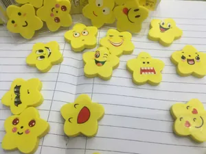Gruppo di gomme gialle a forma di stella con sorrisi su un quaderno a righe bianche