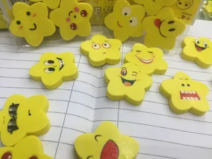 Macro di gomme emoji gialle a forma di stella su carta con simpatiche espressioni facciali