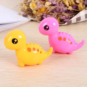 Cute cartoon dinosaur pencil sharpeners in pink and yellow on a wooden desk