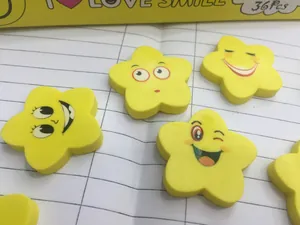 Dettaglio di 36 gomme gialle a forma di stella con faccine sorridenti su un quaderno
