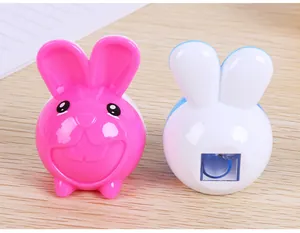 Détail de taille-crayons lapin mignons en rose et bleu sur un bureau en bois clair