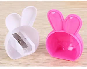 Détail de taille-crayons lapin mignons en blanc et rose sur une surface en bois
