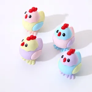Detail of four colorful cartoon chicken pencil sharpeners in pastel pink, blue, and yellow