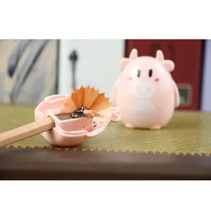 Pink cartoon cow manual pencil sharpener for students with cute smile design on desk