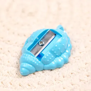 Macro shot of blue shell-shaped pencil sharpener with spiral texture on woven background