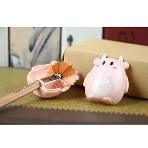 Close-up of cute pink cow pencil sharpener with internal blade and shavings detail