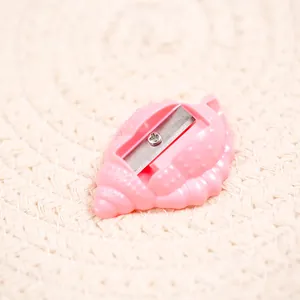 Close-up of pink shell-shaped pencil sharpener with sharp metal blade and screw detail