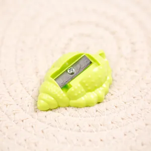 Macro view of shell-shaped pencil sharpener with neon green texture and metal blade