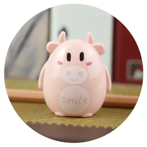 Detail shot of a cute pink cow manual pencil sharpener featuring a smile engraving