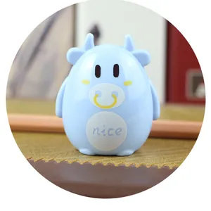 Close-up of a blue cartoon cow pencil sharpener with nice text on a wooden desk