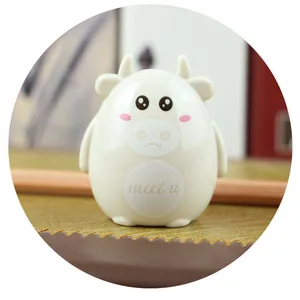 Close-up of cute cartoon cow desk figurine with MEET U text and minimalist design