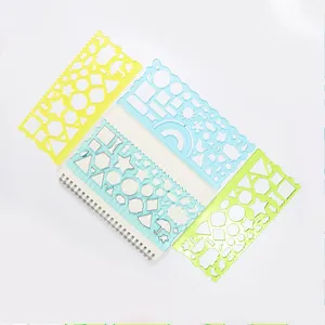 Détail de quatre pochoirs de dessin colorés avec formes géométriques et un carnet à spirale