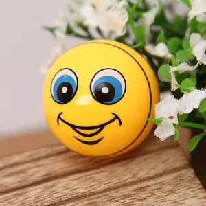 Vibrant yellow soccer ball pencil sharpener with a smiley face on a natural wood surface