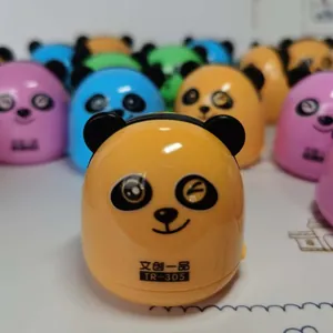 Macro detail of cute panda-shaped desktop vacuum cleaner showing yellow casing and logo