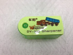 Detail of a mini green and yellow cartoon sharpener showing the pencil entry hole