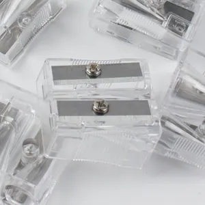 Close-up of stacked clear plastic double-hole pencil sharpeners with metal blades