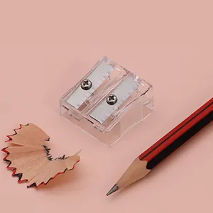 Detail of dual-hole transparent pencil sharpener with sharp metal blades on pink background