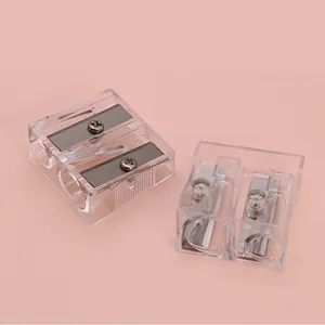 Close-up of dual-hole manual pencil sharpener with transparent shell and steel blades