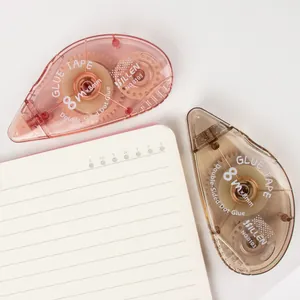Close-up of pink and brown 8m dot glue tape rollers on a notebook with gear mechanism
