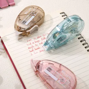Trois rouleaux d'adhésif double face 8m colorés sur un carnet pour loisirs créatifs