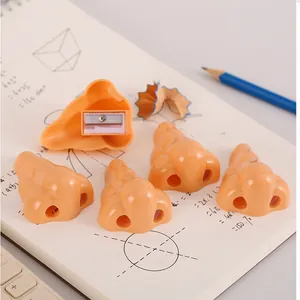 Set di temperamatite divertenti a forma di naso per studenti su un quaderno con matite