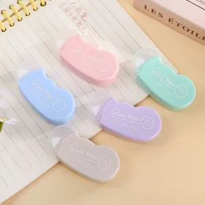 Fünf Kleberoller in Macaron-Farben 6mm x 6m ordentlich auf einem Notizbuch angeordnet