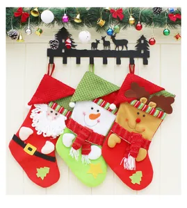 Trois chaussettes de Noël classiques avec Père Noël, bonhomme de neige et renne au mur