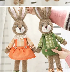 Vista dettagliata dei coniglietti pasquali di peluche con vestito arancione e salopette