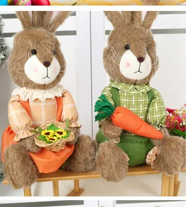 Detail of plush Easter bunnies with sunflowers and carrots on a wooden bench