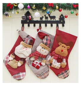 Calze natalizie appese con Babbo Natale, pupazzo di neve e renna 3D su muro di legno