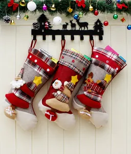 Détail de trois chaussettes de Noël 3D avec personnages de Père Noël, Bonhomme de neige et Renne