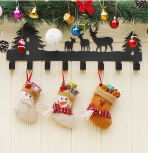 Black metal reindeer wall hooks featuring hanging Santa, snowman, and elk plush stockings