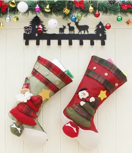 Detail of burlap Christmas stockings with 3D Santa and Snowman hanging on a wall