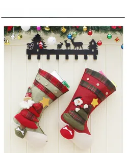 Detail of Christmas stockings with Santa and snowman 3D plush on wooden wall