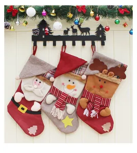 Dettaglio di tre calze natalizie con Babbo Natale, pupazzo di neve e renna su ganci