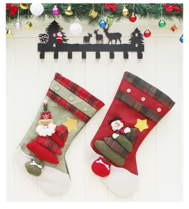 Detail of decorative Christmas stockings with 3D Santa and Snowman hanging on hooks